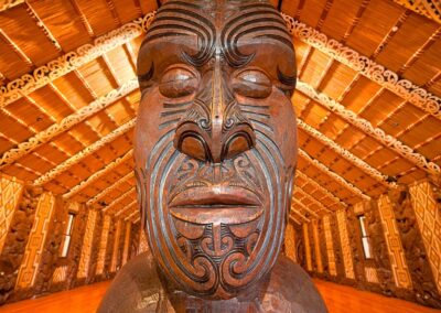 Voyage sur mesure en Nouvelle-Zélande : Gros plan d’une sculpture maorie traditionnelle à l’intérieur du Te Whare Rūnanga aux Waitangi Treaty Grounds, Nouvelle-Zélande