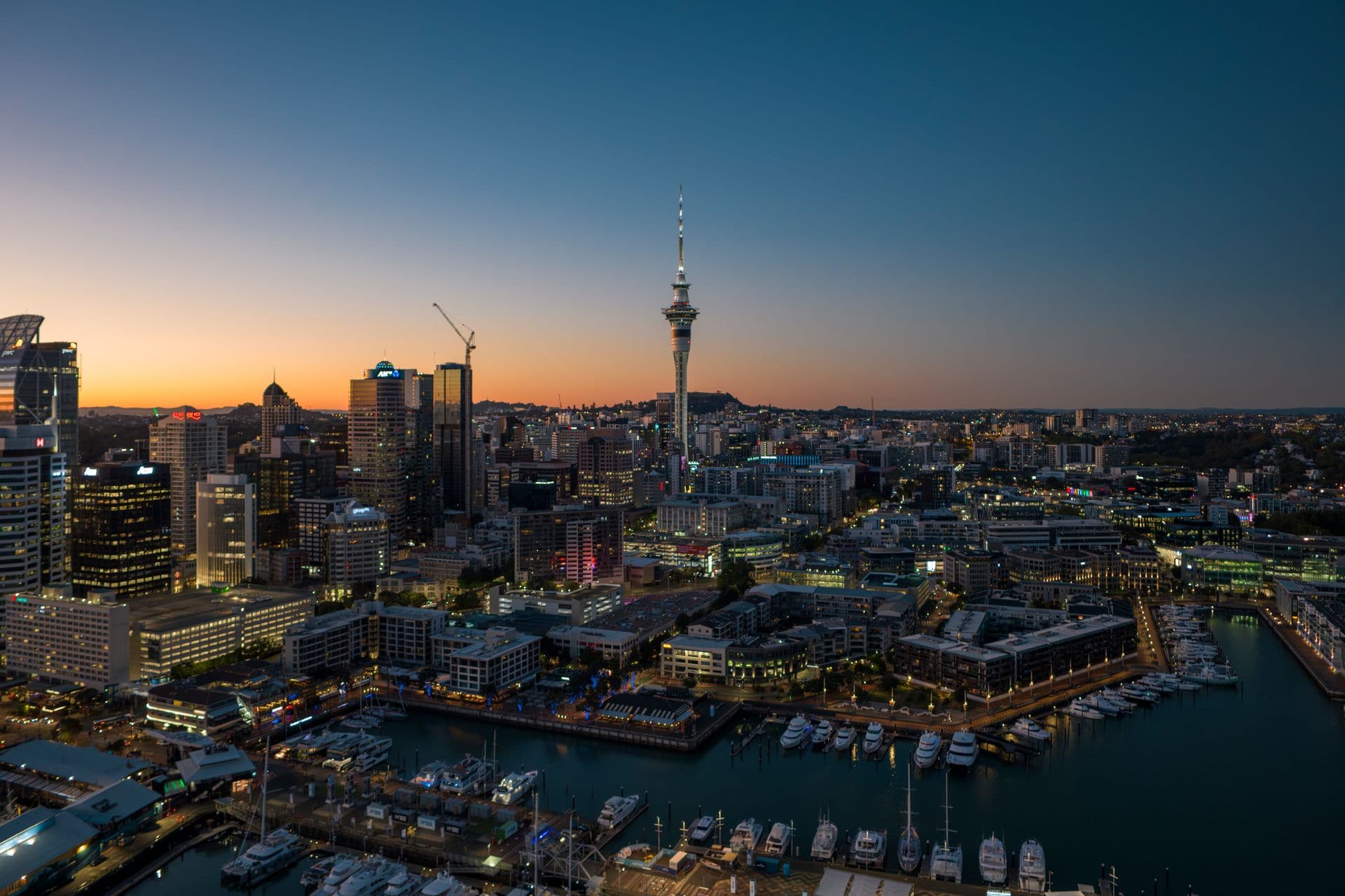 Voyage incentive en Nouvelle-Zélande : Vue panoramique d’Auckland et de la Sky Tower au coucher du soleil.