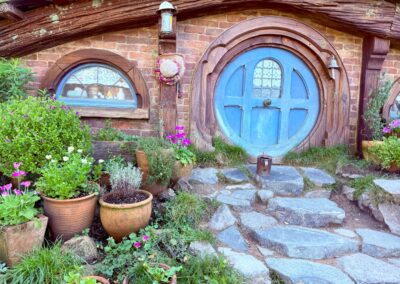 Voyage Nouvelle-Zélande entre amis : Porte et fenêtre bleues d'un trou de Hobbit - village de Hobbiton à Matamata, région de Waikato.