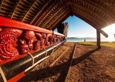 Voyage incentive en Nouvelle-Zélande : Grand waka maori sculpté et peint de rouge exposé sous un abri traditionnel aux Waitangi Treaty Grounds, Nouvelle-Zélande