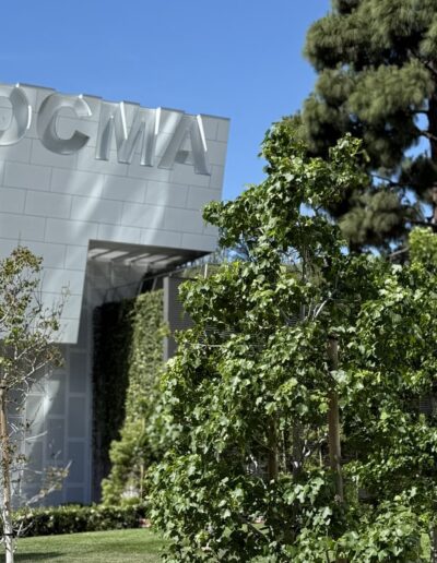 Voyage sur mesure en Californie : Façade moderne du musée OCMA à Costa Mesa entourée d’arbres sous un ciel bleu.