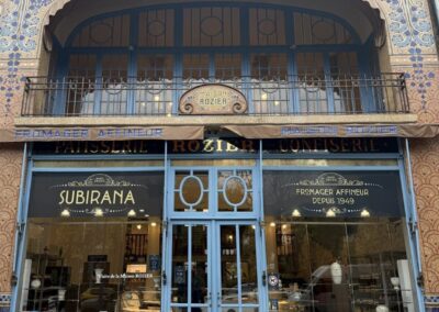 Escapade entre amis en Auvergne : Mosaïque bleue gravée "Gentil Bourdet, mosaïstes, Billancourt", signature d'atelier sur la façade de la Maison Rozier.