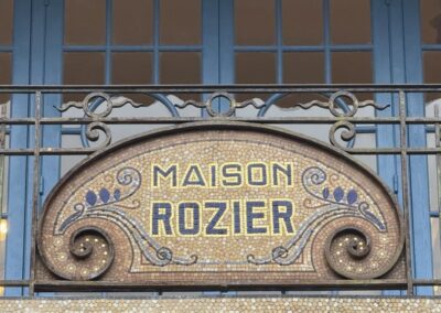 Escapade entre amis en Auvergne : Mosaïque bleue gravée "Gentil Bourdet, mosaïstes, Billancourt", signature d'atelier sur la façade de la Maison Rozier.