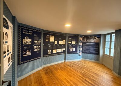 Voyage sur mesure en Auvergne : Salle d'exposition circulaire avec panneaux muraux bleu marine retraçant la frise chronologique de l'histoire de la Maison Rozier depuis 1904.