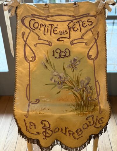 Voyage sur mesure en Auvergne : Bannière ancienne en soie jaune "Comité des Fêtes 1909, La Bourboule", peinte à la main d'iris violets, avec franges dorées.