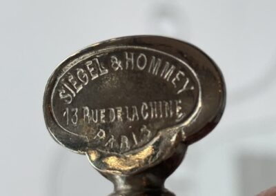 Voyage sur mesure en Auvergne : Gros plan sur une plaque en métal gravée de la marque Siegel et Hommey, située au 13 rue de la Chine à Paris.
