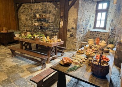 Voyage sur mesure en Auvergne :Cuisine médiévale reconstituée au château de Murol avec tables garnies de victuailles.