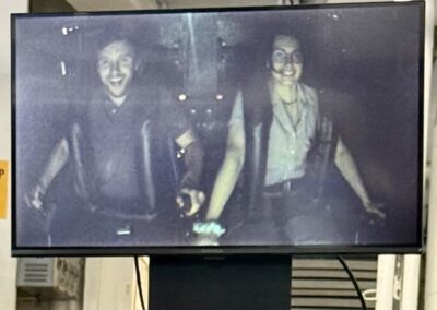 Visite hors des sentiers battus en Californie : Écran affichant l'enregistrement vidéo de la session de simulateur de vol, avec les deux passagers souriants sanglés dans le cockpit (San Diego).