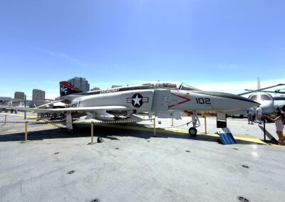Voyage sur mesure en Californie : Chasseur « F-4 Phantom II » aux couleurs de l'USS Midway, exposé sur le pont d'envol avec la skyline de San Diego.