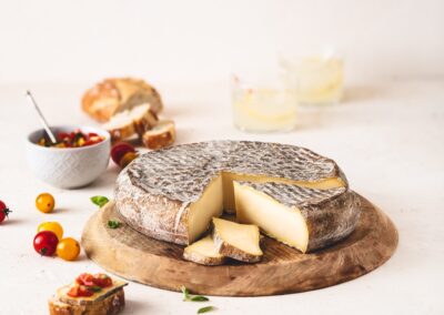 Voyage sur mesure en Auvergne : Saint-Nectaire AOP entier et en morceaux sur une planche en bois.