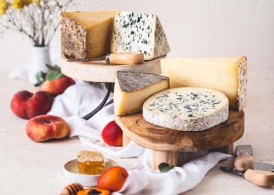 Visite hors des sentiers battus en Auvergne : Plateau de fromages des 5 AOP d’Auvergne dans une ambiance printanière, accompagné de fruits.