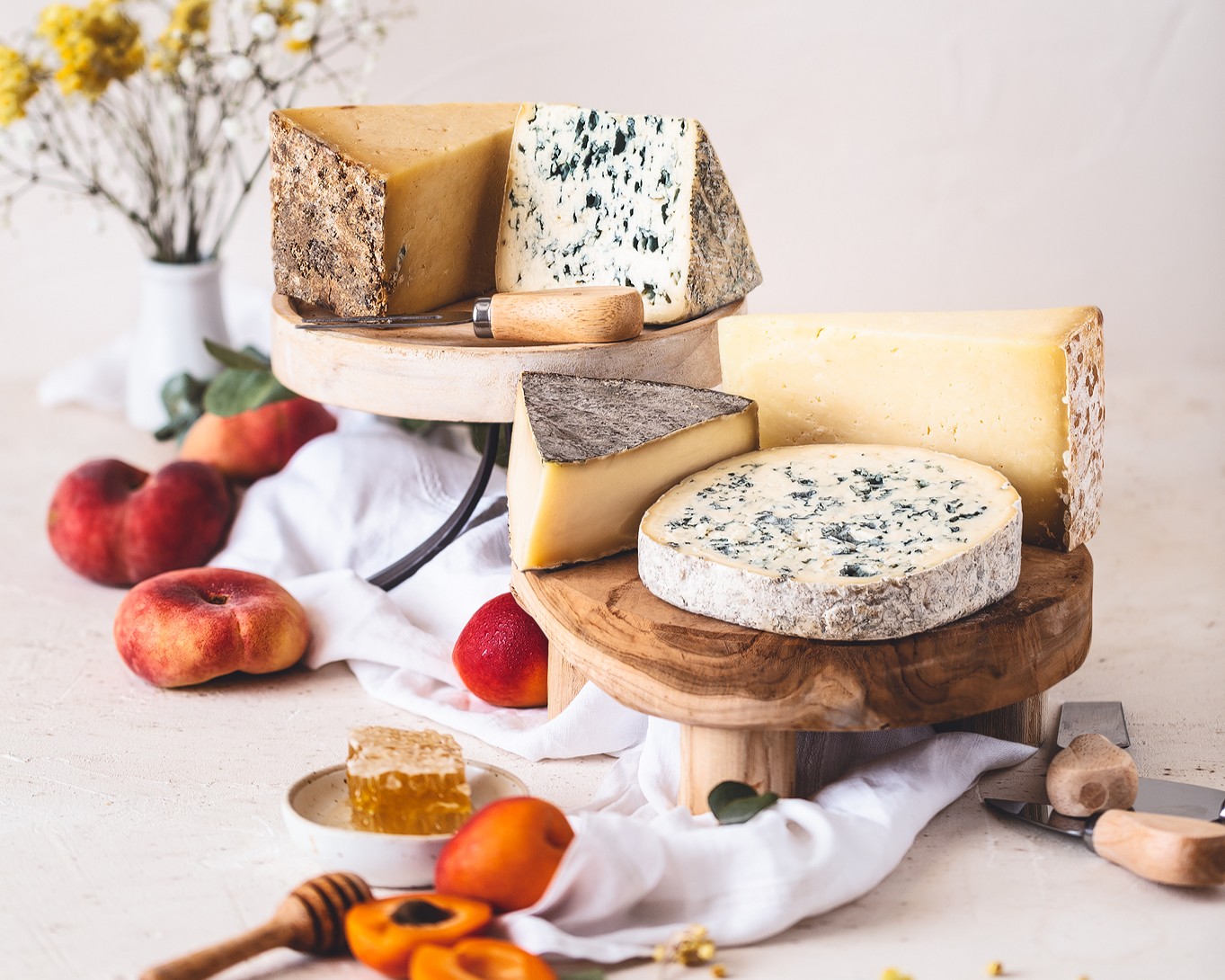 Visite hors des sentiers battus en Auvergne : Plateau de fromages des 5 AOP d’Auvergne dans une ambiance printanière, accompagné de fruits.