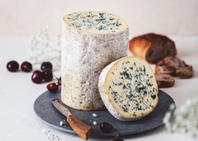 Escapade entre amis en Auvergne : Fourme d’Ambert AOP entière et en tranche, avec sa pâte persillée.