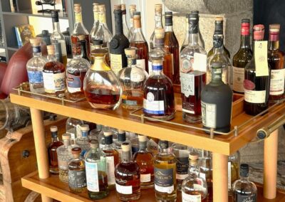 Visite hors des sentiers battus en Bretagne : Chariot en bois garni de rhums, whiskies, cognacs et armagnacs au bar du domaine de Rochevilaine.