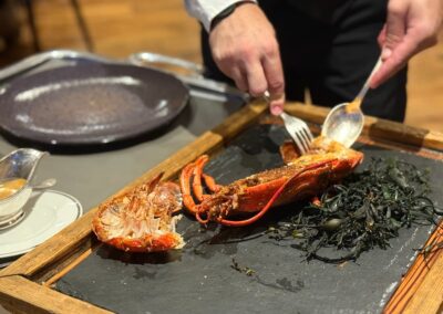 Séjour sur mesure en Bretagne : le maître d’hôtel décortique le homard bleu après cuisson (Domaine de Rochevilaine).